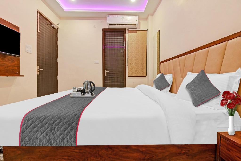 een slaapkamer met een wit bed en een telefoon. bij Townhouse Kalyanpur Metro in Kaliānpur
