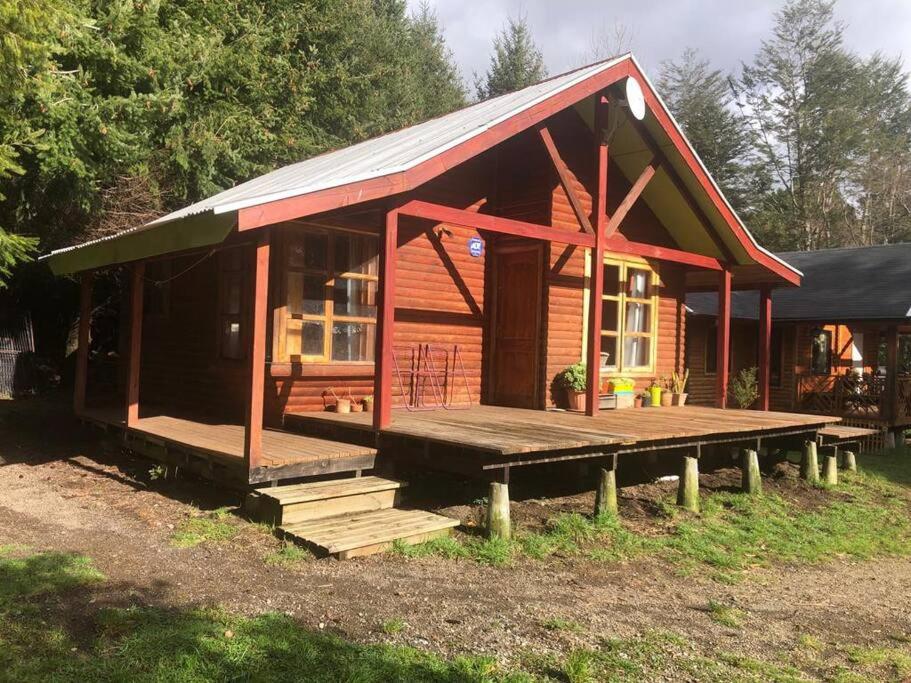 a small wooden house with a porch and a deck at Cabaña Haywood in Puerto Varas