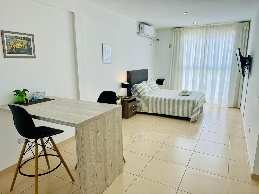 a room with a desk and a bedroom with a bed at Moderno y Nuevo Departamento Parque Saavedra La Plata in La Plata