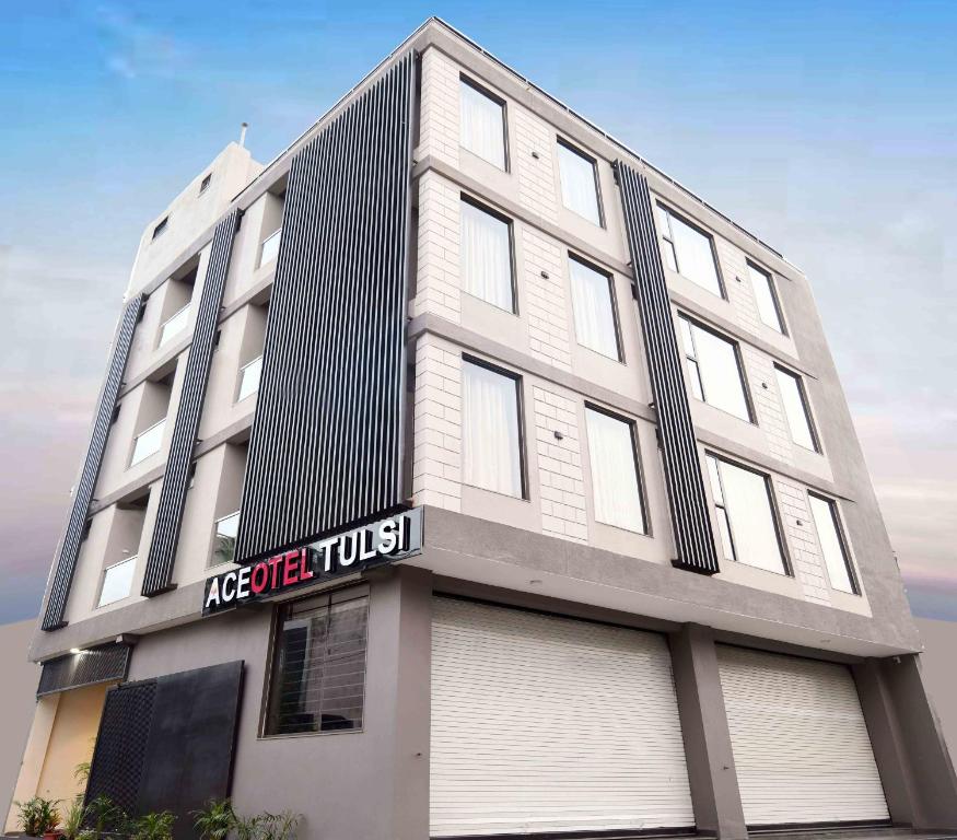 a large white building with a sign on it at Aceotel Select Tulsi Vijay Nagar in Indore