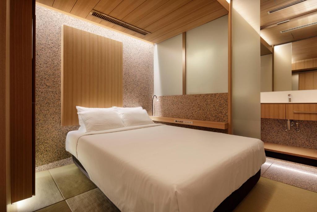 a bedroom with a large white bed in a room at KOYADO HOTEL Adult only in Tokyo