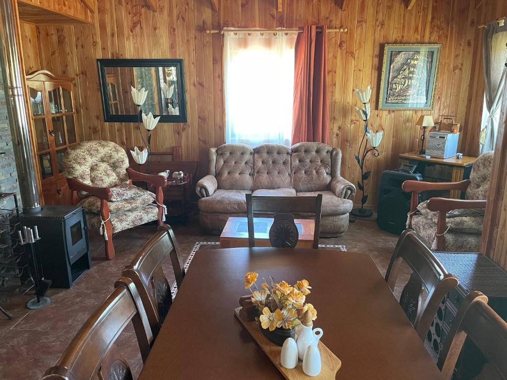 a living room with a table and a couch at Cabaña Ojo del Volcán in Pucón