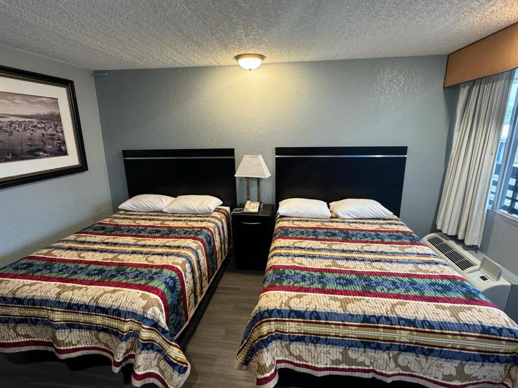 a hotel room with two beds and a window at Midtown Lodge in Jacksonville