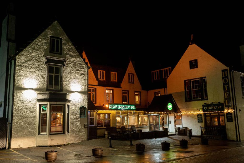 a group of buildings in a town at night at New Inn Hotel in Ellon