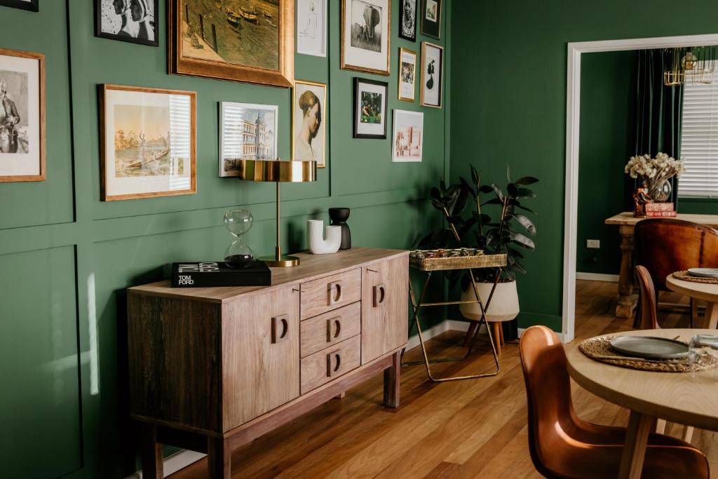 a dining room with green walls and a wooden cabinet at Fancy Fritz B&B in Swakopmund