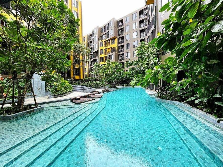 a large swimming pool in a city with buildings at Phuket Town - Central Luxury in Phuket Town