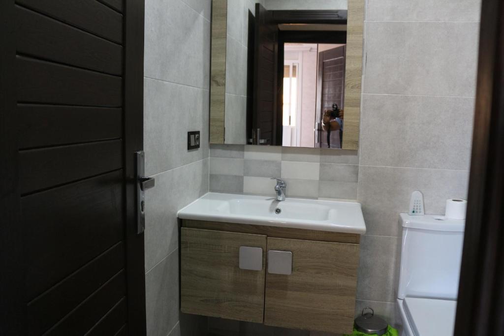 ein Badezimmer mit einem Waschbecken, einem Spiegel und einem WC in der Unterkunft Luxury Apartment II Nador Jadid Free Parking & Wifi in Nador