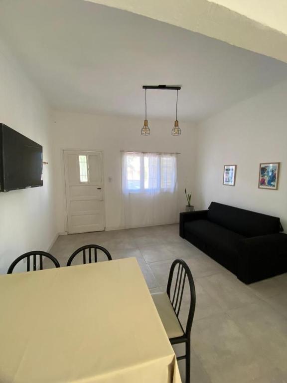 ein Wohnzimmer mit einem Tisch, Stühlen und einem Sofa in der Unterkunft Casa a 400 M de la playa in Mar del Plata