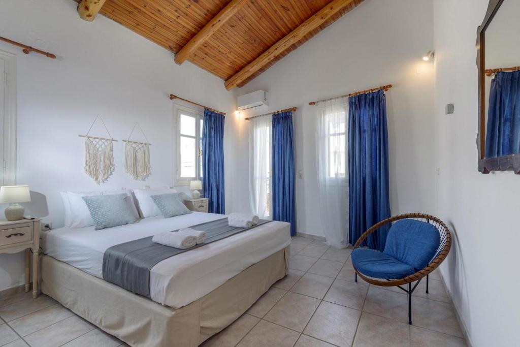 1 dormitorio con 1 cama y 1 silla azul en Rethymno Heart, en Áyios Andónios