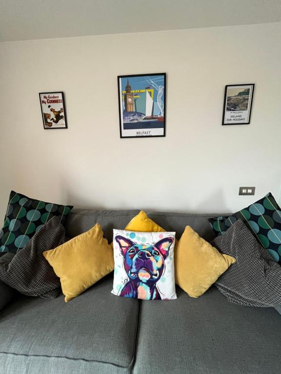 a gray couch with pillows on top of it at City Centre Luxury Apartments in Belfast