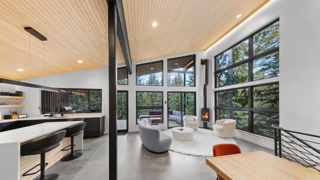 a living room with large windows and a table at Ravn Haus in Government Camp