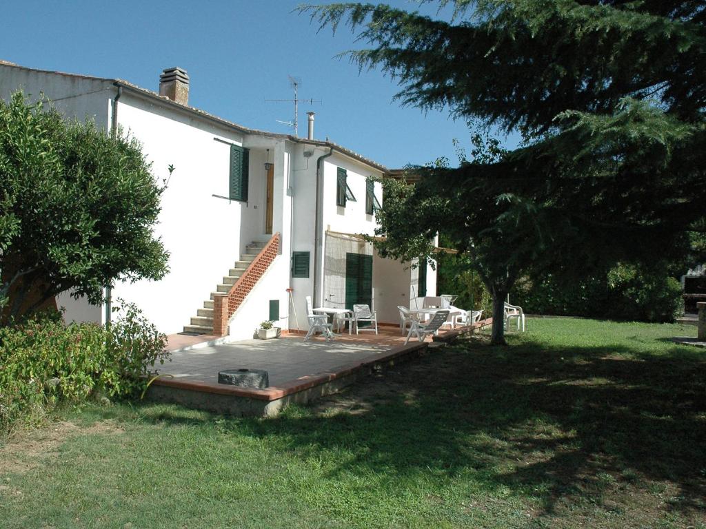 ein weißes Haus mit einer Holzterrasse im Hof in der Unterkunft Casa Del Mandorlo in Marina di Campo