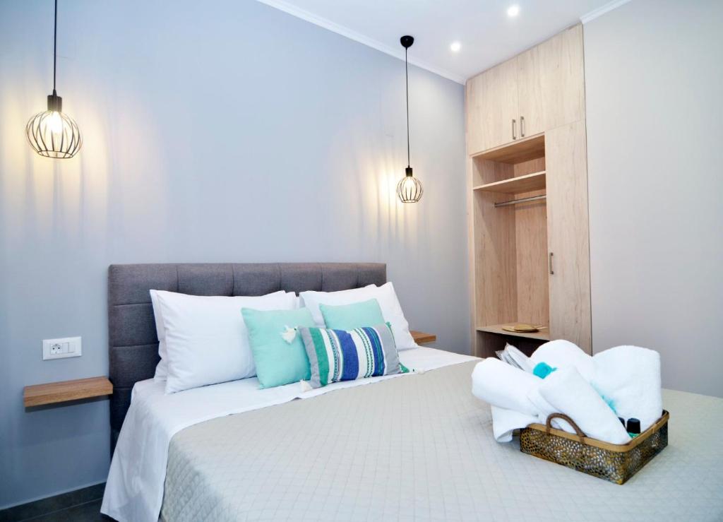 una camera da letto con un letto con cuscini bianchi e blu di Olgas cozy home a Chania