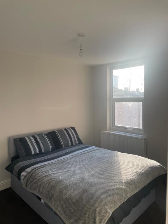 uma cama num quarto branco com uma janela em Double Bedroom em Londres