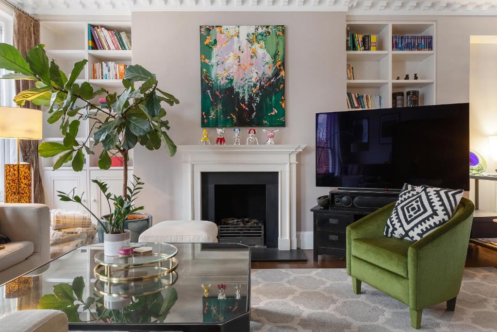 a living room with a fireplace and a tv at Luxurious Apartment in Kensington in London