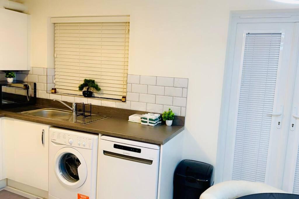 a kitchen with a washing machine and a sink at Mo Apartment in Accrington