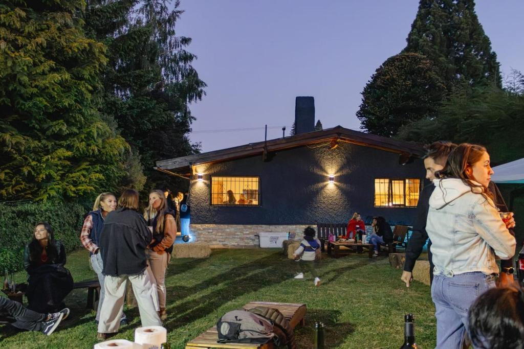 a group of people standing in front of a house at Las Viñas Hostel Boutique in San Carlos de Bariloche