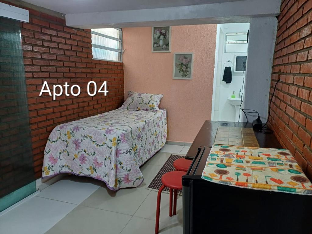 a bedroom with a bed and a table with a table at Jardim Santa Rosália in Sorocaba