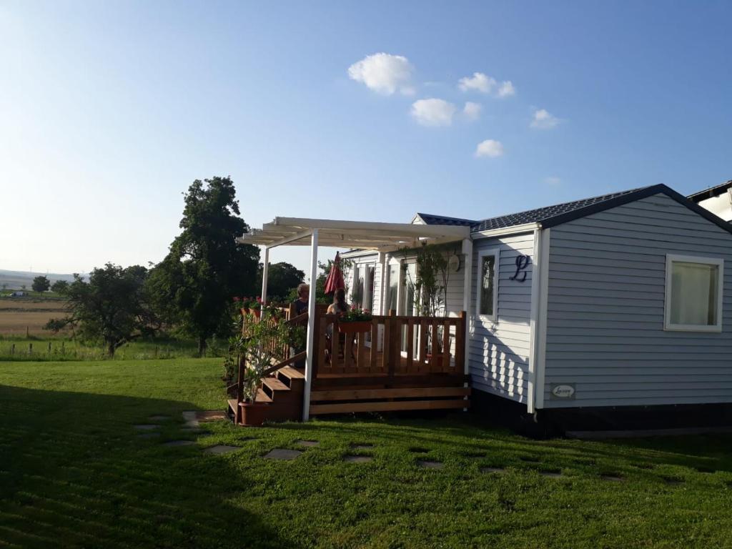 ein kleines Haus mit einer Veranda und einer Terrasse in der Unterkunft Tiny House Natur-Traum Zur Burg Eltz in Wierschem