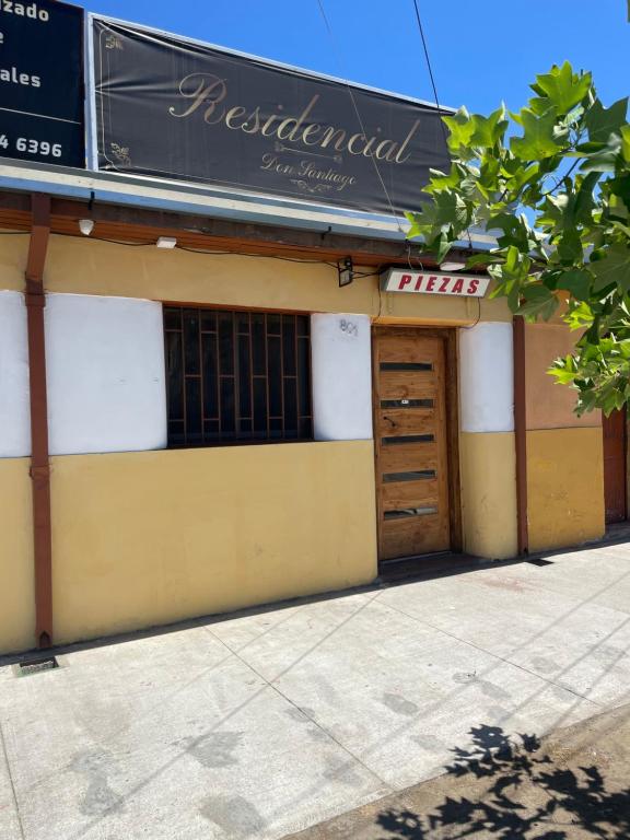 un magasin avec un panneau sur le côté d'un bâtiment dans l'établissement Residencial Don Santiago, à Talca
