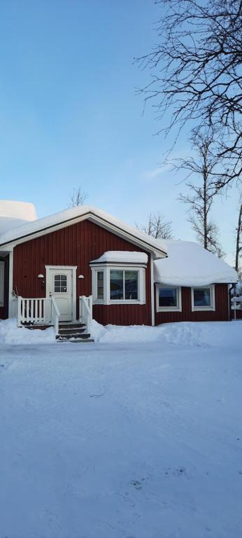 uma casa vermelha com neve em frente em Kiruna accommodation Gustaf Wikmansgatan 6b villa 8 pers em Kiruna