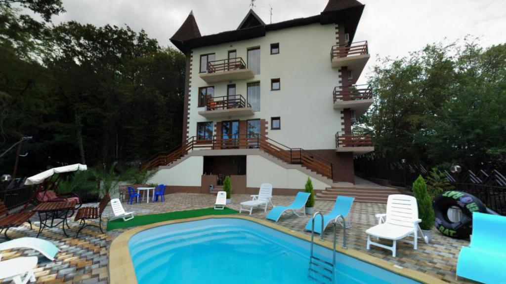 una casa con piscina frente a un edificio en Guest House Villa Nadezhda, en Lazarevskoye