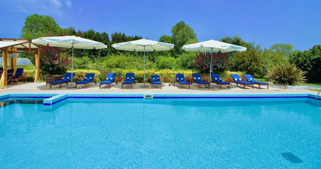 a swimming pool with blue chairs and umbrellas at CA' LEONE - Regina Vittoria - Apartment with Pool in Mira
