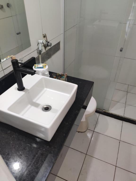 een badkamer met een witte wastafel en een spiegel bij Vista Maravilhosa 706 in Fortaleza