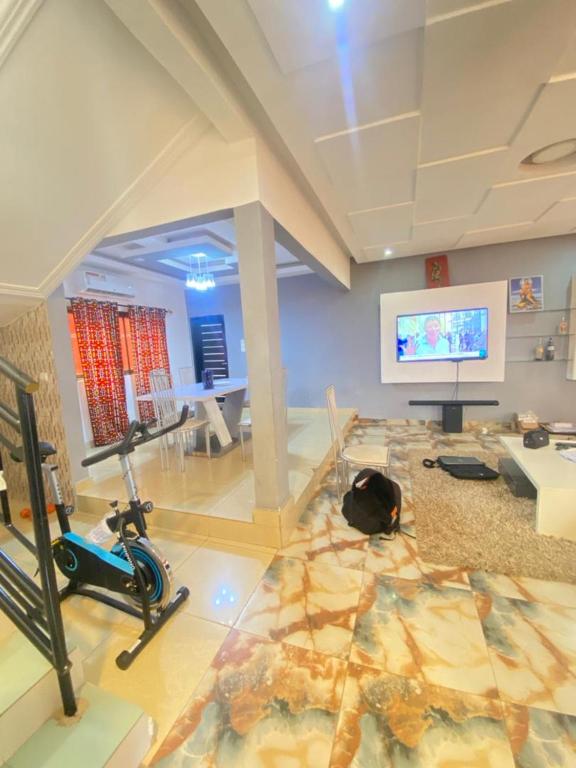 um quarto com um ginásio e uma televisão de ecrã plano em Villadeluxe3 em Abomey-Calavi