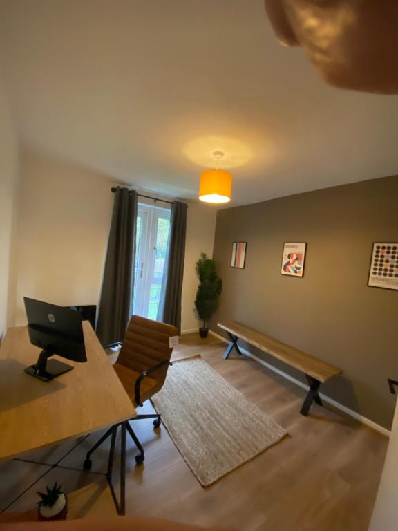 a living room with a desk and a laptop computer at The Cwtch - Apartment in Cardiff/Penylan in Cardiff