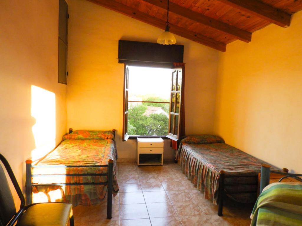 una habitación con dos camas y una ventana en Descanso Serrano, en Tanti