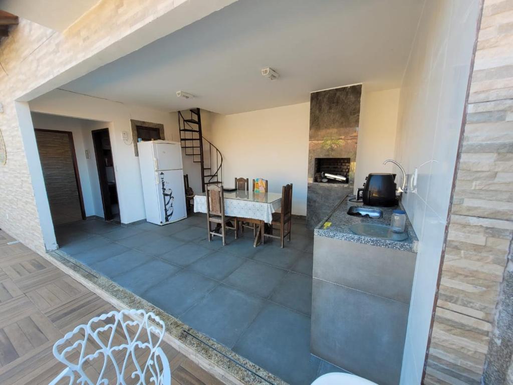 a kitchen and living room with a table and a refrigerator at Cakau House - espaço amplo e aconchegante in Maricá