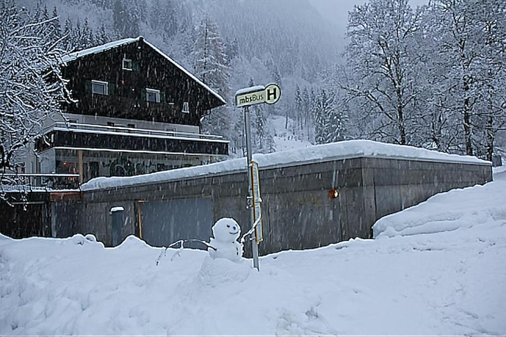 a snowman in a pile of snow next to a house at Haus am Rain in Partenen