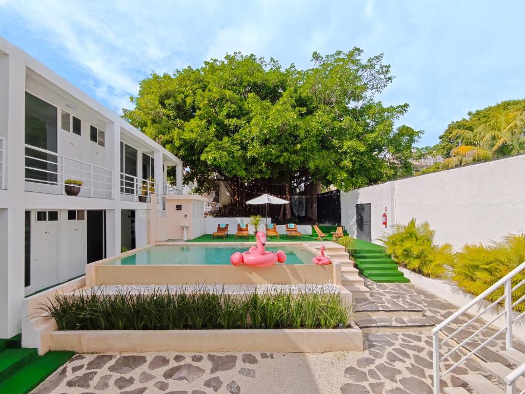 une piscine avec un radeau gonflable rose dans une arrière-cour dans l'établissement La Quinta Caribeña, à Playa del Carmen