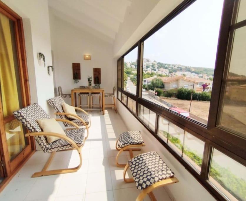 een kamer met stoelen en ramen en een tafel bij Acogedor apartamento con vistas 80 m2 in Alcossebre