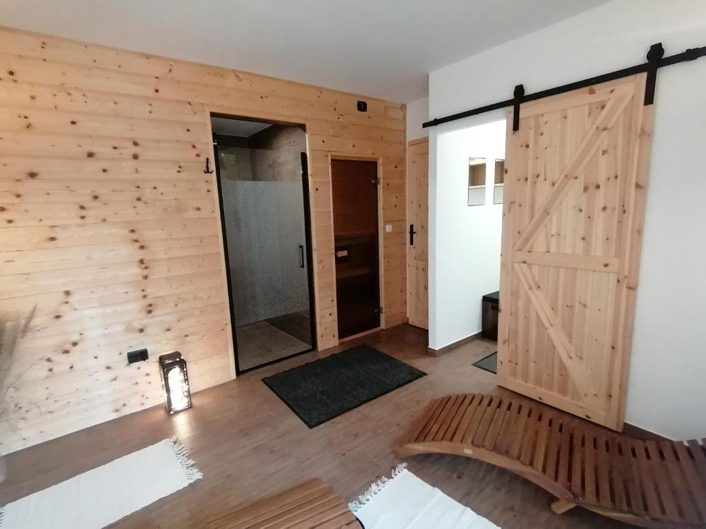 a room with a wooden wall and a sliding door at Domki pod Derkaczem in Radków