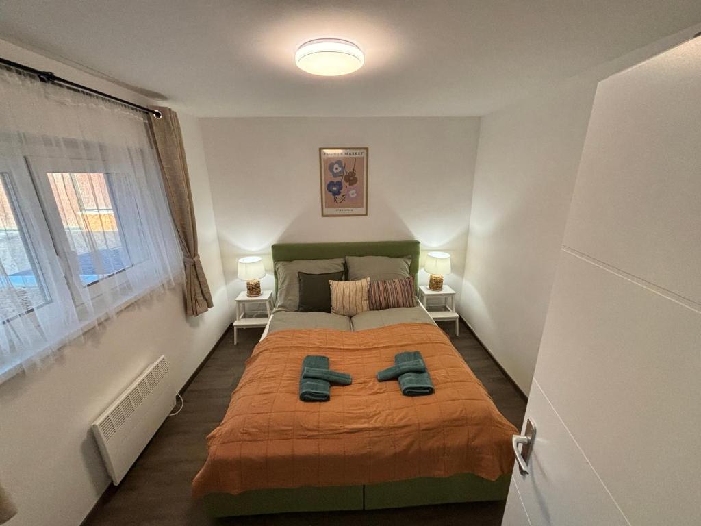 ein Schlafzimmer mit einem Bett mit zwei Schuhen drauf in der Unterkunft Szeglet Apartman in Andornaktálya