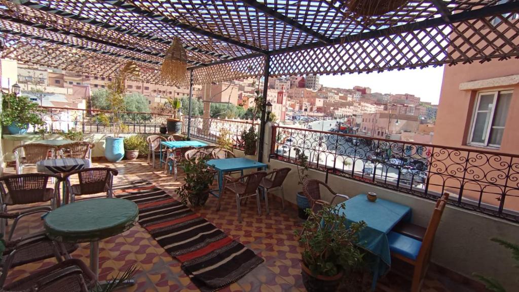 a patio with tables and chairs and a view of a city at Hôtel Restaurant BOUGAFER in Oulad Akkou