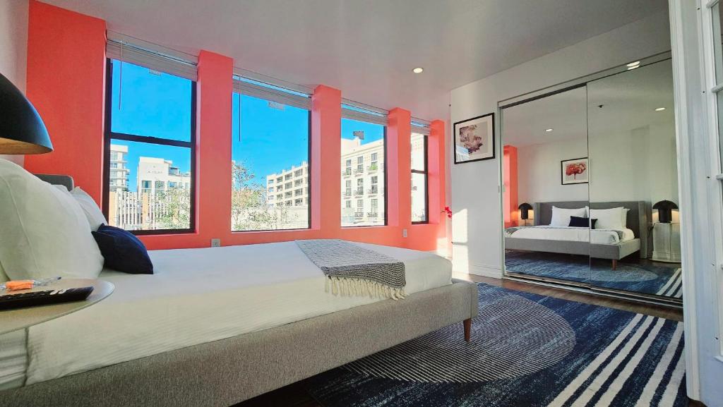 um quarto com uma cama grande, paredes vermelhas e janelas em The Lofts on Clematis 301 Downtown West Palm Beach em West Palm Beach