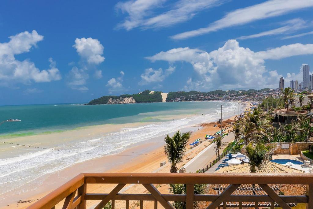 a view of a beach with palm trees and the ocean at Seaside #16 - Flat em Ponta Negra por Carpediem in Natal