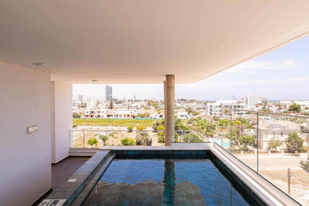 einen Pool in einem Haus mit Aussicht in der Unterkunft YAMAS Urban Living Sunny Pool Penthouse in Limassol