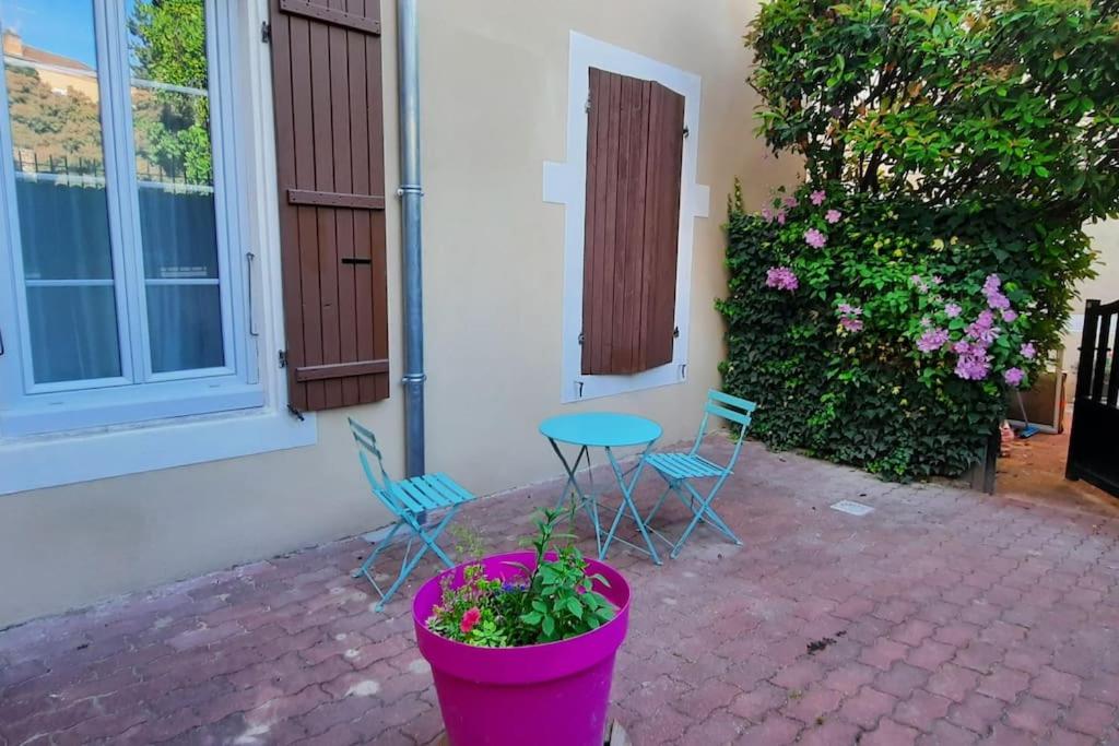 - une terrasse avec une table, des chaises et des fleurs dans l'établissement Charmant appartement centre ville avec cour, à Chalon-sur-Saône