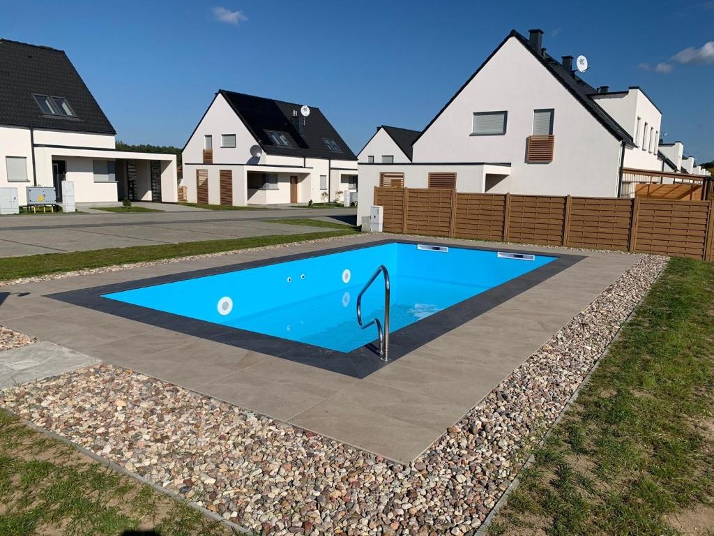 a swimming pool in front of a house at Ferienhaus Lilja mit Garten und Pool in Trzęsacz