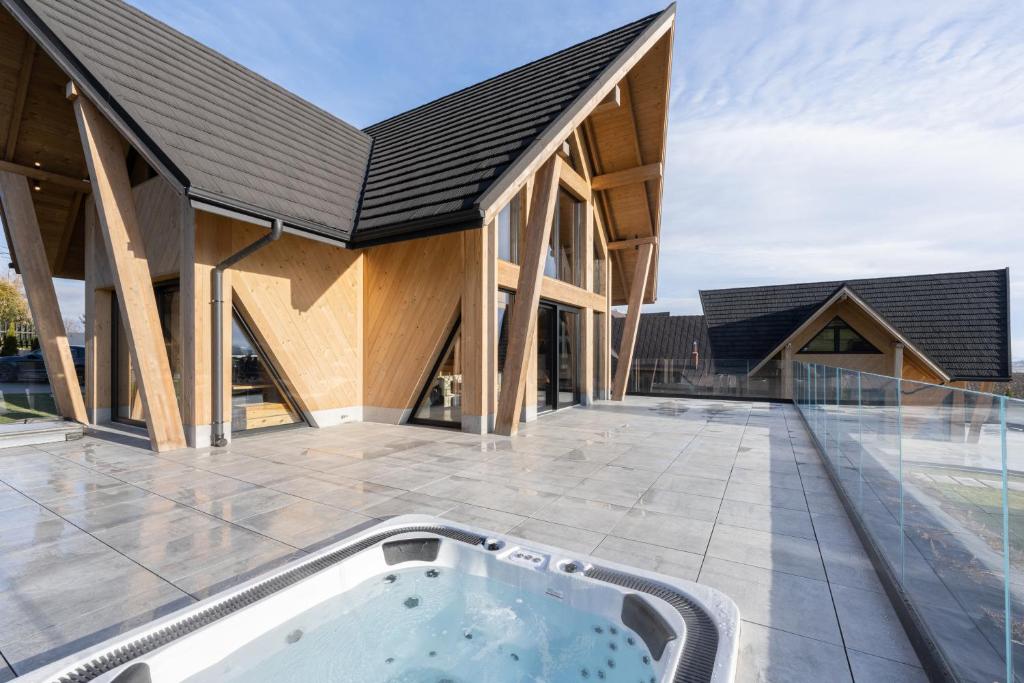 an exterior view of a house with a hot tub on a patio at Chaletovo Mountain Residences in Zakopane