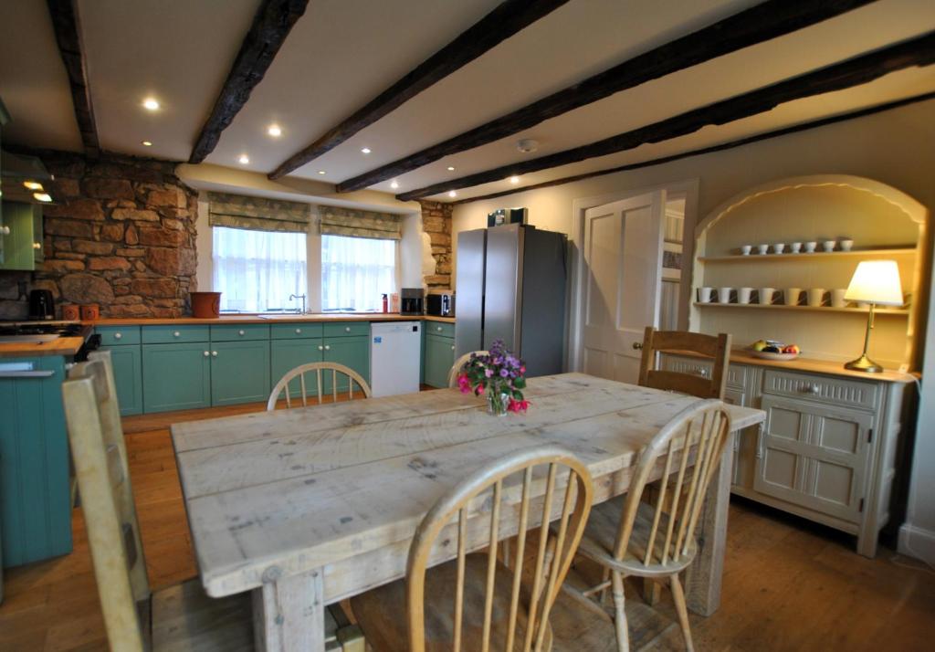 a kitchen with a table with chairs and a refrigerator at St Annes Crail- grand family home in Crail