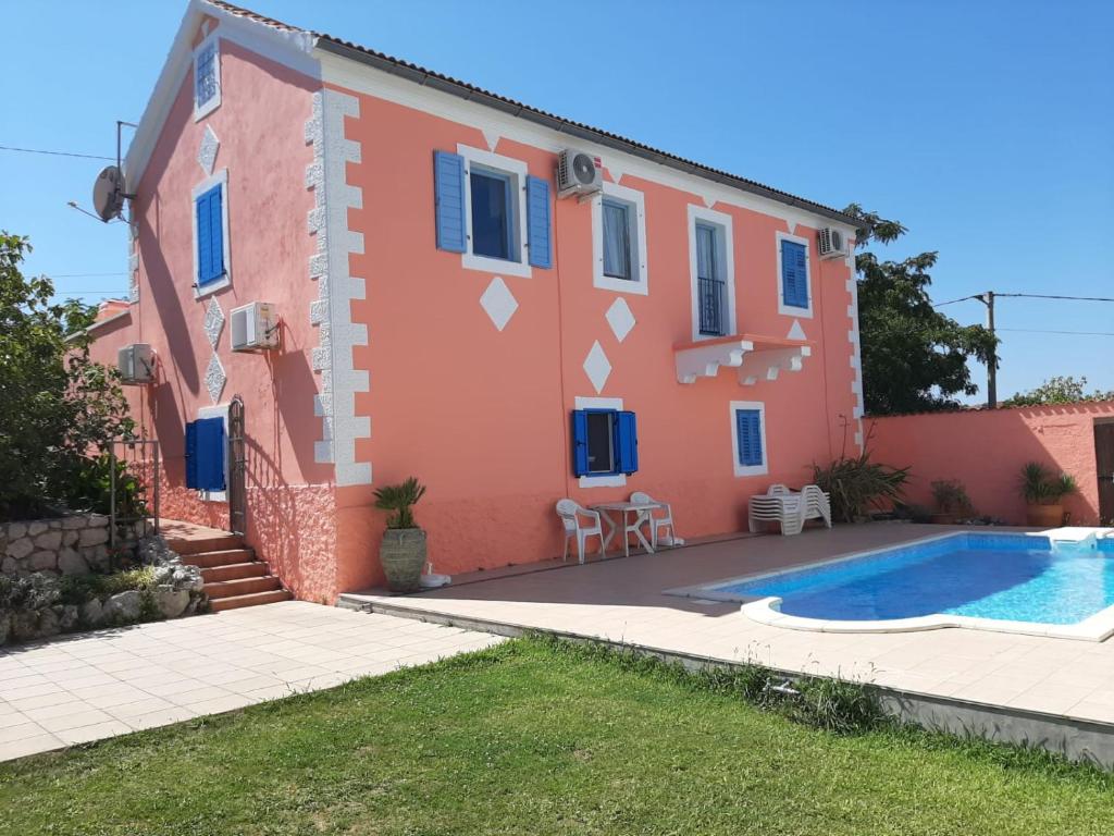 a house with a swimming pool in front of it at Holiday House Ivana in Dobropoljana
