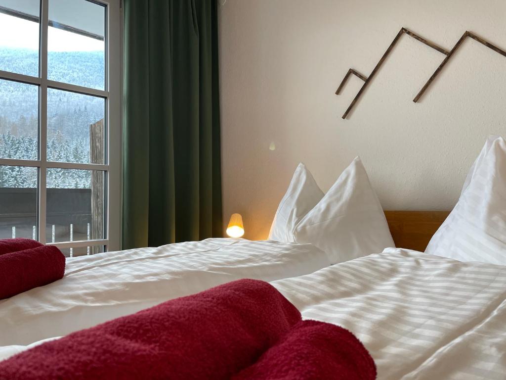 a bedroom with a white bed with a window at Pension 's Waldeck in Traunkirchen