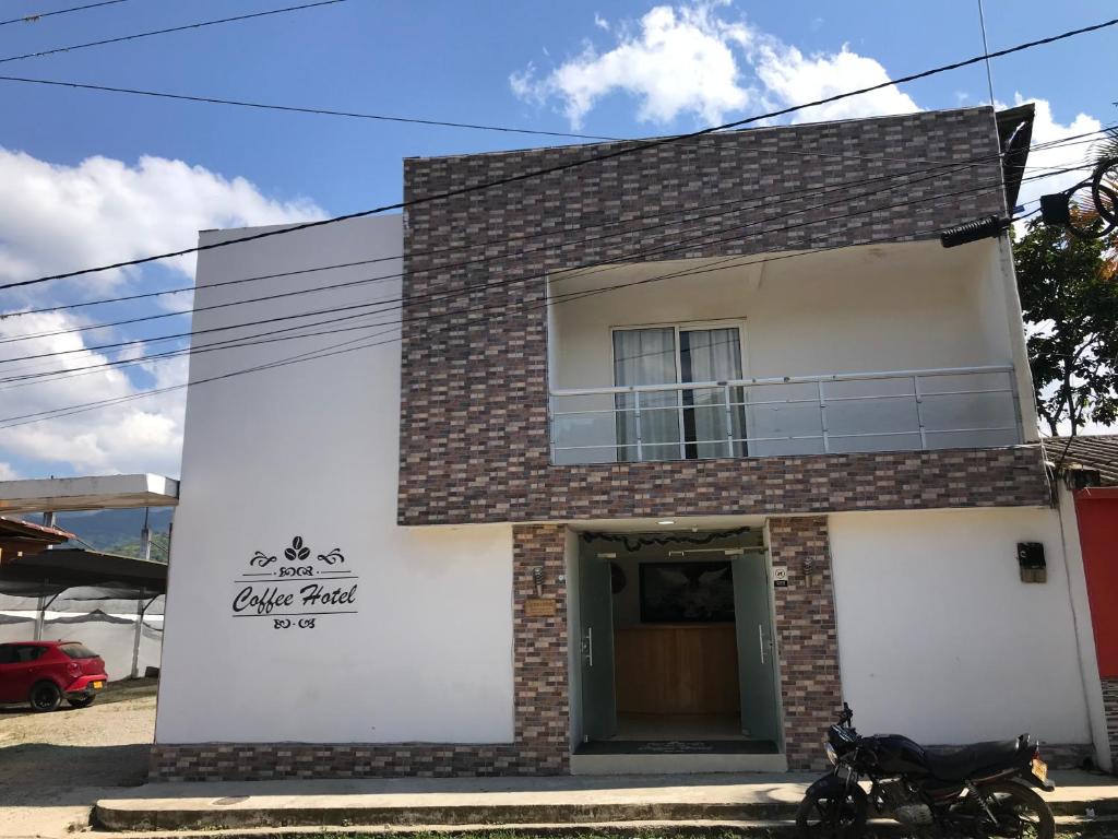 ein Haus mit einem Motorrad, das davor geparkt ist in der Unterkunft Coffee Hotel in Planadas