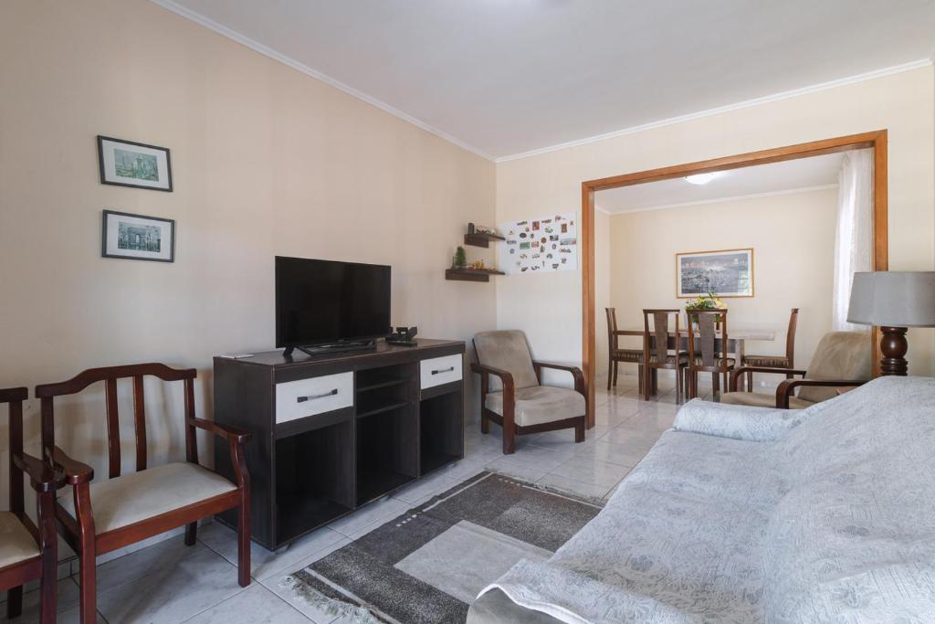 ein Wohnzimmer mit einem Sofa und einem TV in der Unterkunft Linda casa c Wi-Fi a 400m da Praia de Xangri-la RS in Xangri-lá