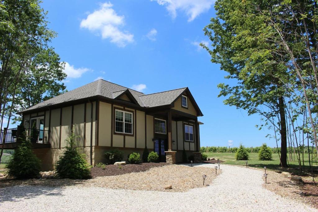 a house on a gravel road with trees at Vineyard Woods in Geneva